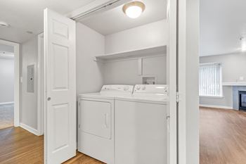 a white laundry room with a washer and dryer  at The Buttes Apartments Loveland, CO